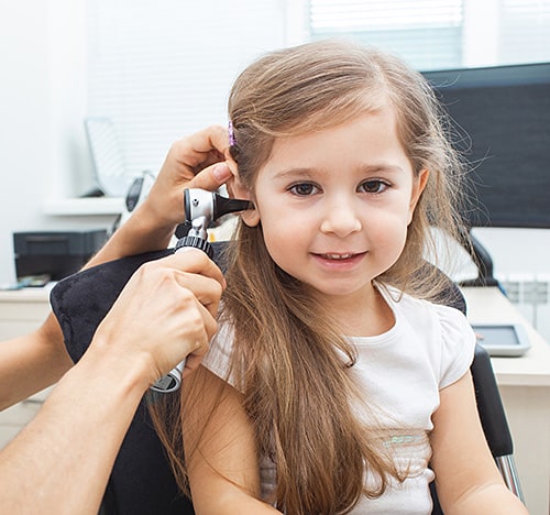 Ear 2 Pediatric ear services young child smiling while ent doctor looks at her ears