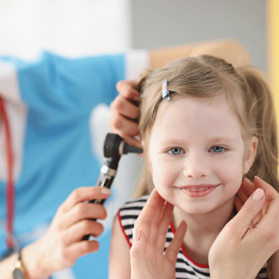 Doctor checking little girl's ear for pediatric ear infections